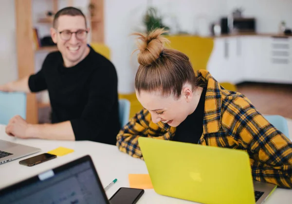 Man laughing looking at a girl who is bend over laughing  Man laughing looking at a girl who is bend over laughing