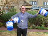 Man holding 3 fundraising buckets 