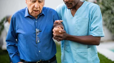Male nurse helping old man walk Male nurse helping old man walk