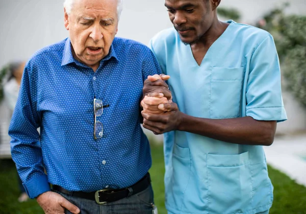 Male nurse helping old man walk Male nurse helping old man walk